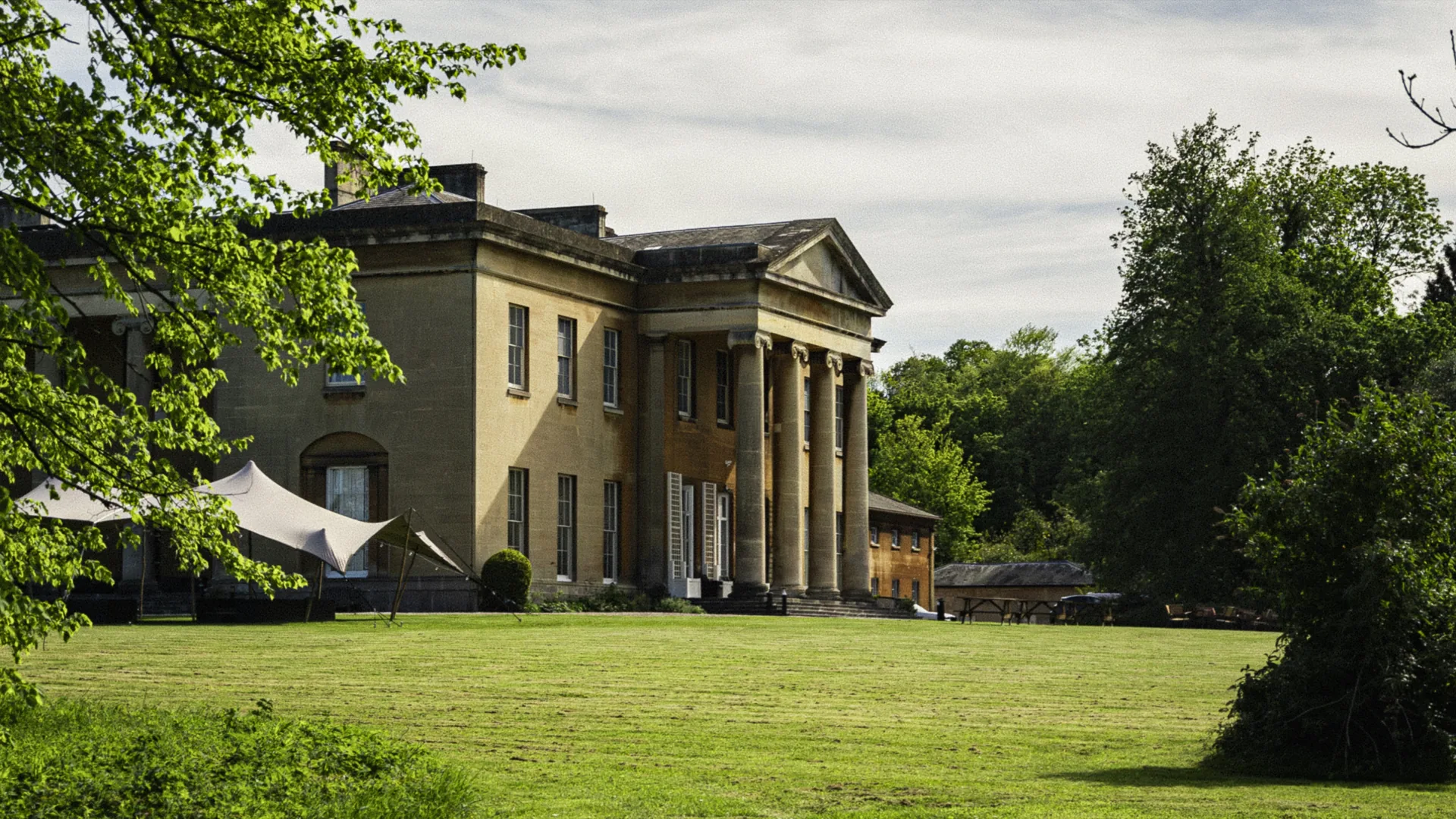The mansion seen through tree branches.
